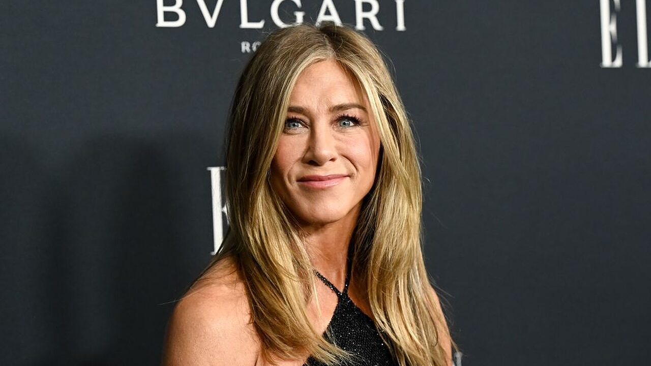 Jennifer Aniston smiling in halterneck dress