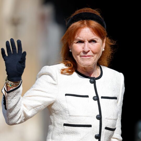 Sarah Ferguson waving in white and black blazer