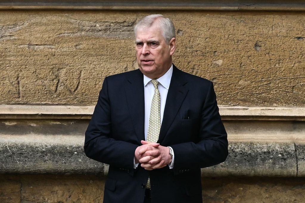 Andrew Mountbatten-Windsor wearing a suit and clasping his hands